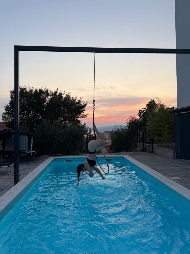 Aerial Hoop über dem Pool bei Sonnenuntergang